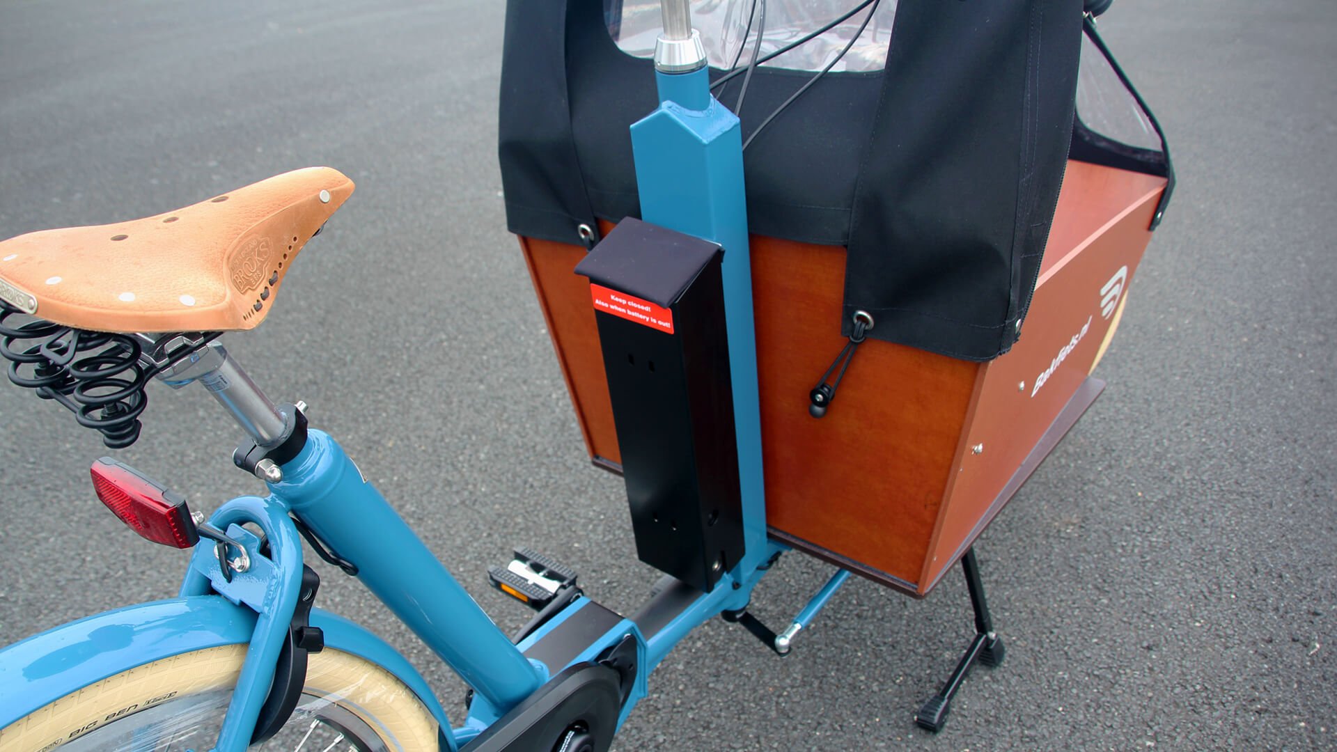 La batterie est fixée contre la colonne de direction