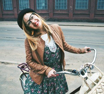 Cheerful woman with a bike in a street